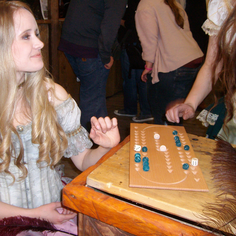 Eine elegante, junge Dame spielt Samsara in einer Taverne